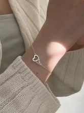 Armband mit ineinandergreifenden Herzanhängern